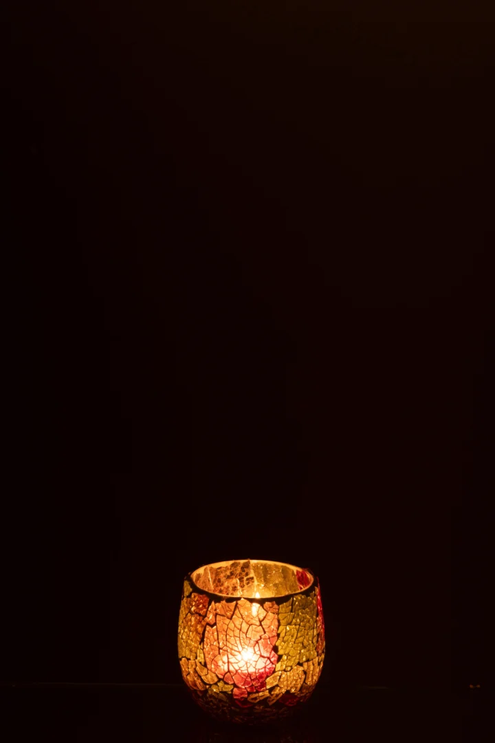 De Kaarsenhouder Zonsondergang Glas Multi Klein schijnt warm in het donker, de mozaïek glazen houder creëert een vredige en gezellige sfeer.