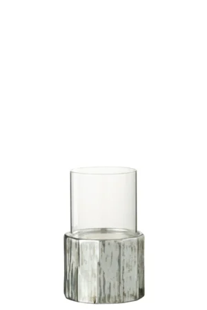 De Kaarsenhouder Ary Klei Zilver Klein is een heldere, cilindervormige glazen theelichthouder op een ronde, zilverkleurige en witte gestructureerde voet die doet denken aan een boomstam of steen, afgebeeld tegen een witte achtergrond.
