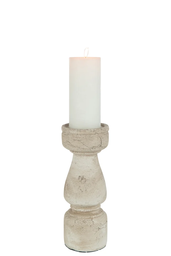 Een witte pilaarkaars wordt aangestoken en geplaatst op de Kaarsenhouder Terracotta Beige Groot, een rustieke stenen kandelaar met textuur en een ronde basis, tegen een witte achtergrond.