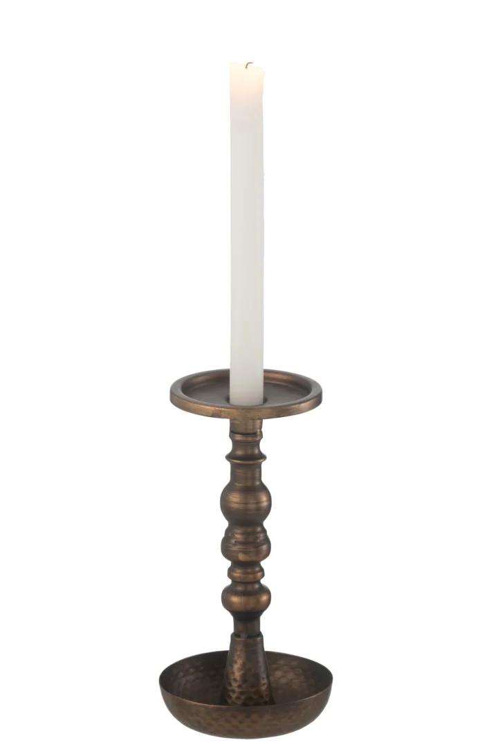 Een witte kaars staat rechtop in de Kaarsenhouder Jere Metaal Bruin, een sierlijke bronzen kandelaar met een brede voet en decoratieve steel.