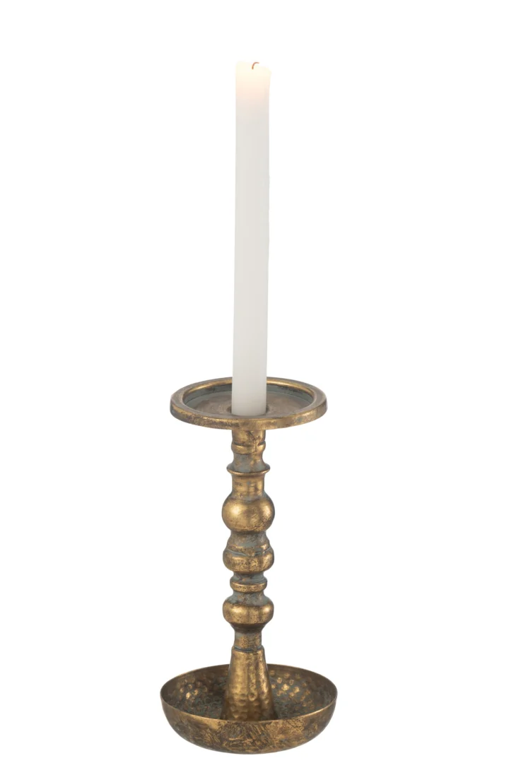 Een hoge witte kaars staat rechtop in de Kaarsenhouder Jere Metaal Goud, een sierlijke houder van gehamerd messing met een ronde voet en decoratieve steel.