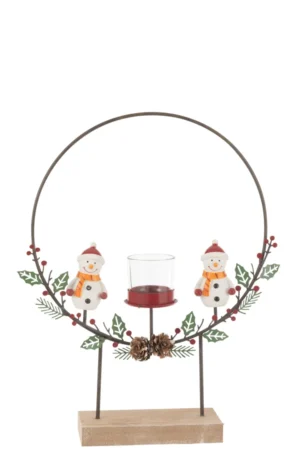 Theelichthouder Cirkel Op Voet Sneeuwmannen Mix is een feestelijke kandelaar met twee sneeuwpoppen in sjaals en mutsen, dennenappels, hulstbladeren en bessen op een cirkelvormig metalen frame met houten voet en centrale glazen houder.