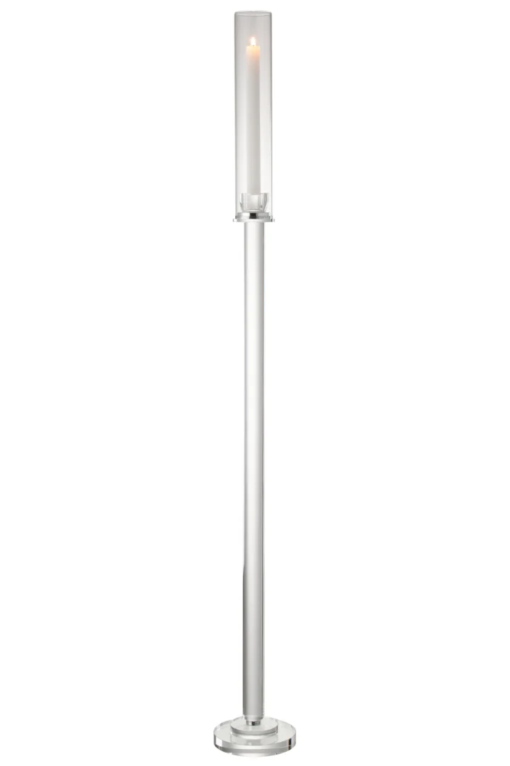 De Kaarsenhouder Moira Glas Transparant Groot is een hoge, slanke zilveren kandelaar met een heldere glazen cilinder boven een witte, brandende kaars op een ronde voet, met een modern minimalistisch ontwerp.