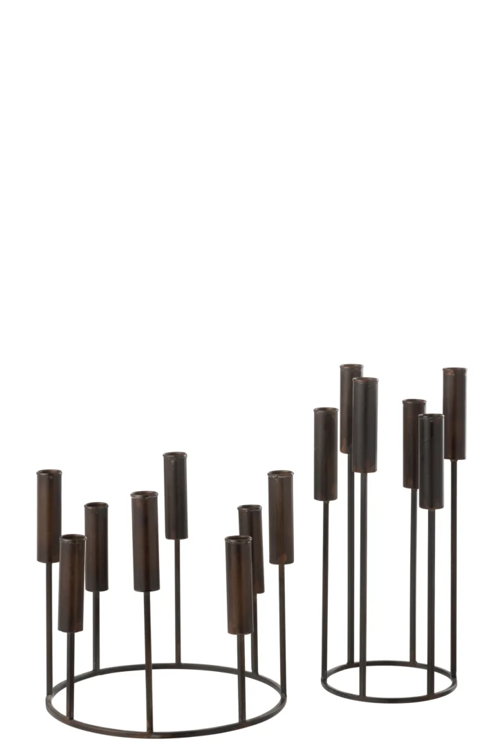 De Kaarsenhouder Pierre IJzer Zwart Set van 2 heeft twee moderne zwart metalen kandelaars: een ronde en lage, de andere hoog en ovaal, beide met cilindrische sleuven op verschillende hoogtes en een open, minimalistisch ontwerp.