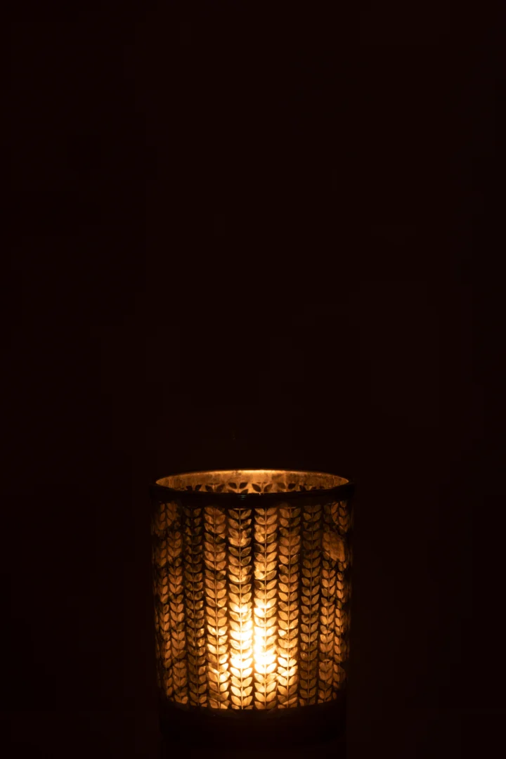 De Kaarsenhouder Orkaan Visgraat Glas Groen Zilver Medium werpt een warme, zachte gloed in de duisternis en verlicht alleen zijn directe omgeving met zijn decoratieve visgraatpatroon.