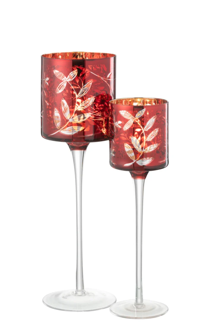 Een kandelaar van rood glas met geëtste witte bladmotieven, op een lange, slanke heldere steel en geaccentueerd met antiek goud op de rand. Product: Theelichthouder Op Voet Bladeren Glas Rood/Antiek Goud Groot.