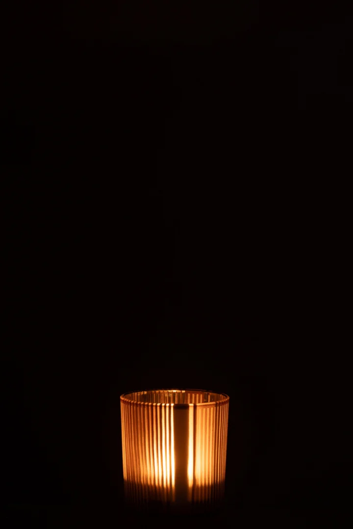 De Theelichthouder Strepen Glas Mat Bruin/Wit Klein kandelaar gloeit warm in het donker, het geribbelde glazen ontwerp creëert een gezellige, minimalistische sfeer.