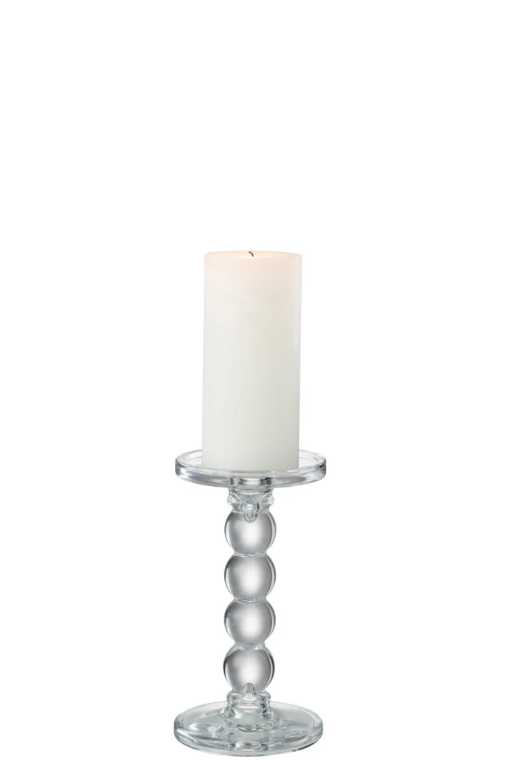 Een witte pilaarkaars wordt aangestoken en geplaatst op de Kaarsenhouder Druppels Glas Transparant Medium, een kandelaar van helder glas met een rond, gestapeld ontwerp tegen een effen witte achtergrond.