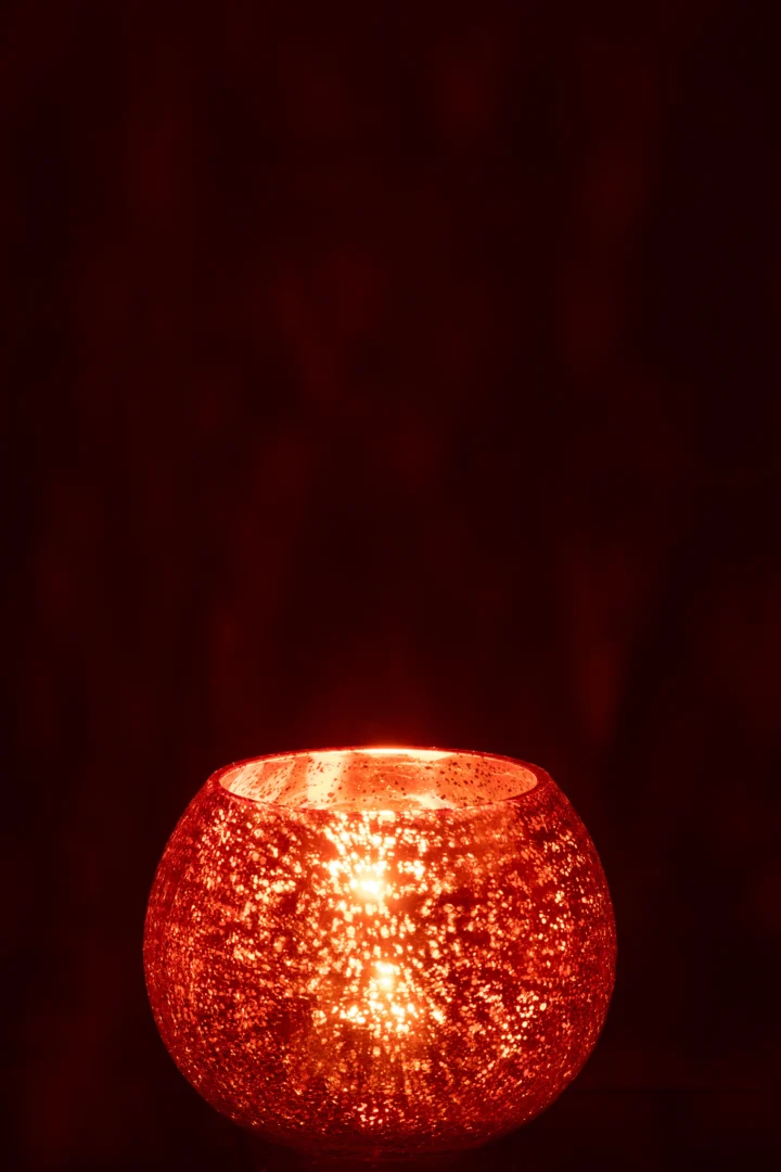 De Theelichthouder Bal Craquelure Glas Oranje Groot heeft een gestructureerd, gebarsten glazen oppervlak en straalt een warme, zachte gloed uit in het donker met zijn levendige oranje tint.