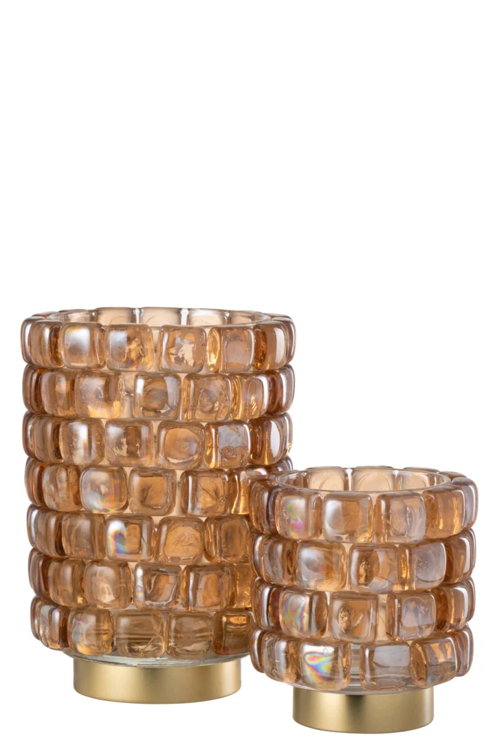 De linker kandelaar is de Kaarsenhouder Hurricane Vierkant Mozaïekglas Cognac Groot, met amberkleurig glas met een verhoogd vierkant patroon en een goudkleurige ronde voet. De kortere versie staat rechts.