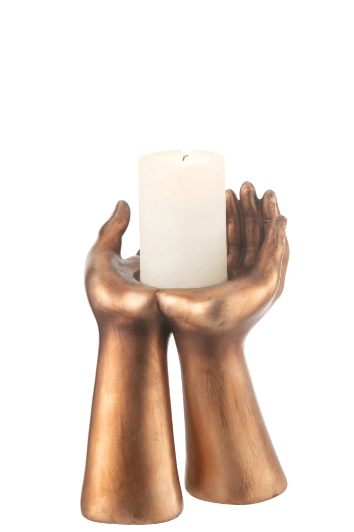 De Kaarsenhouder Palmen Hars Koper is een goudkleurige kandelaar met twee handen die samen een witte pilaarkaars vasthouden op een effen witte achtergrond.