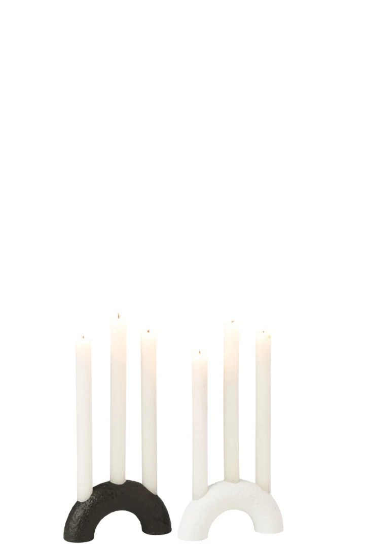 De Kaarsenhouder Boog Cement Zwart Wit Set van 2, met één zwarte en één witte gebogen kandelaar met elk drie hoge witte kaarsen, staat naast elkaar tegen een effen witte achtergrond.