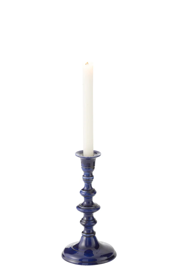 Een witte kaars staat rechtop en brandt zachtjes in de Kaarsenhouder Nag Aluminium Blauw, een glanzende donkerblauwe kandelaar, tegen een effen witte achtergrond.
