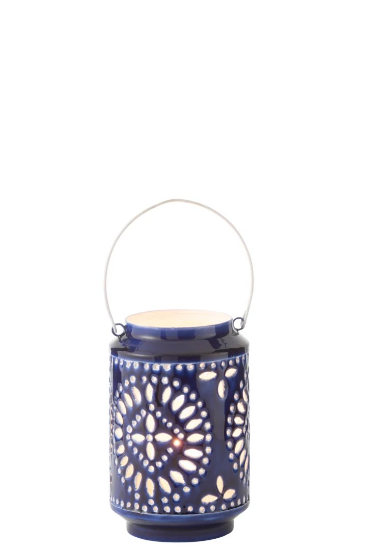 De Kaarsenhouder Orkaan Nag IJzer Blauw Wit Klein is een lantaarn van blauw keramiek met witte cirkelvormige patronen, uitgesneden motieven en een metalen handvat. De lantaarn gloeit zacht wanneer hij van binnenuit wordt aangestoken.
