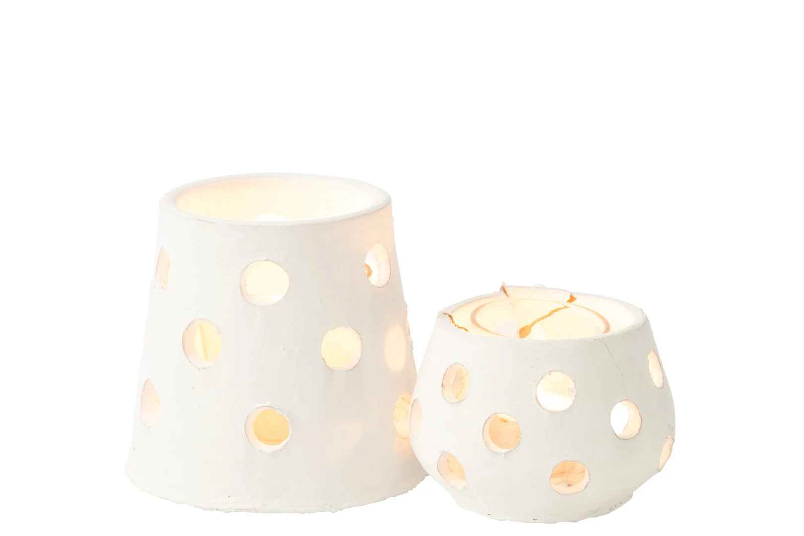 Twee Theelichthouder Ibiza Klei/Glas Wit Smal kandelaars, elk met cirkelvormige uitgesneden patronen en een gloeiende kaars erin, werpen een zacht licht door de gaten. De houders zijn van wit keramiek en verschillen in vorm en grootte.