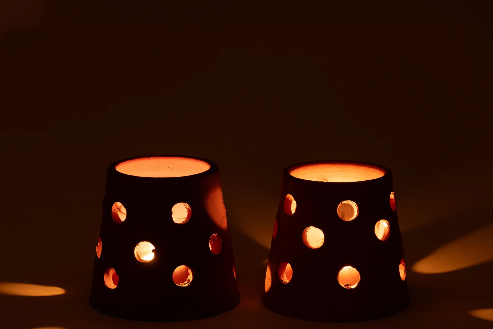 Theelichthouder Gaia Smal Klei Glas Rood Bruin Set van 2: Deze kleine theelichthouders van klei en glas met ronde uitsparingen verspreiden warm licht en zorgen voor een gezellige sfeer in het donker.