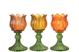 De Kaarsenhouder Tulipa Glas Mix Set 3 bestaat uit drie tulpvormige vintage glazen kandelaars in oranje, geel en rood, elk met een groen gestructureerde basis, naast elkaar geplaatst op een witte achtergrond.