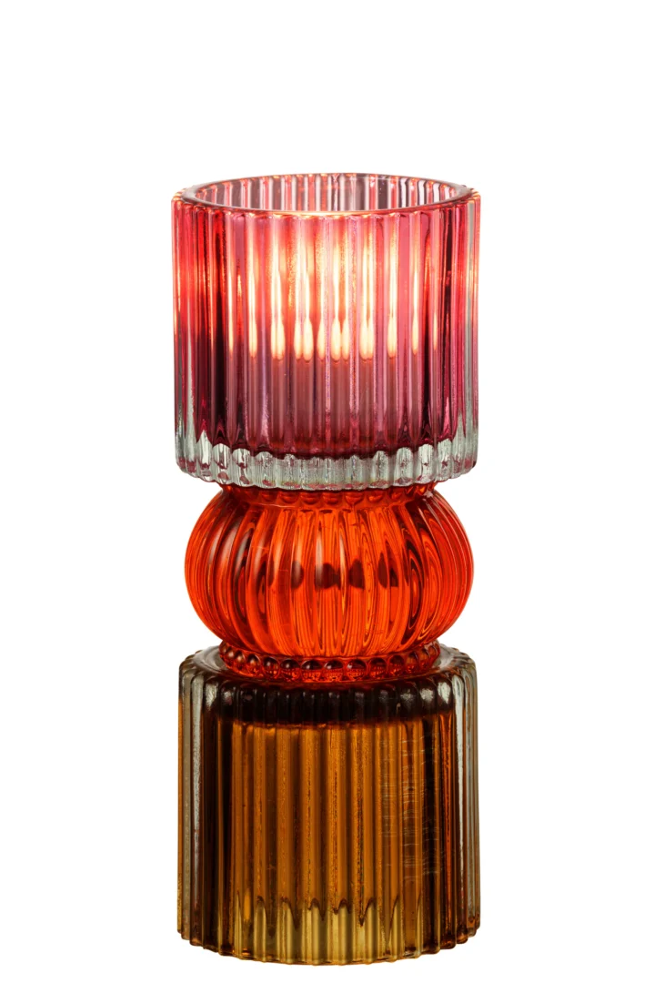 De Kaarsenhouder Jazzy Glas Mix is een glazen kandelaar met drie gestapelde segmenten in roze, oranje en amber, met verticale ribbelpatronen en een brandende kaars erin.