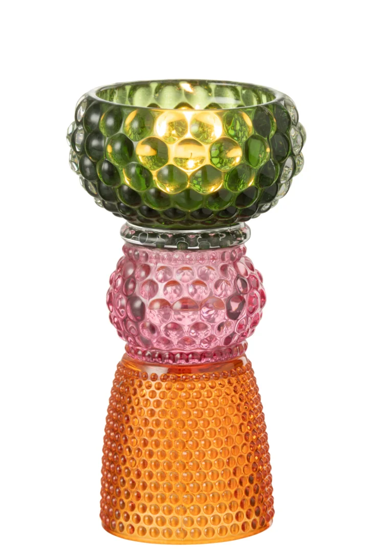 De Kaarsenhouder Jazzy Glas Mix is een kleurrijke glazen kaarsenhouder met drie op elkaar gestapelde delen - groen bovenaan, roze in het midden en oranje onderaan - elk met een bubbelpatroon en een brandende kaars in het groene deel.