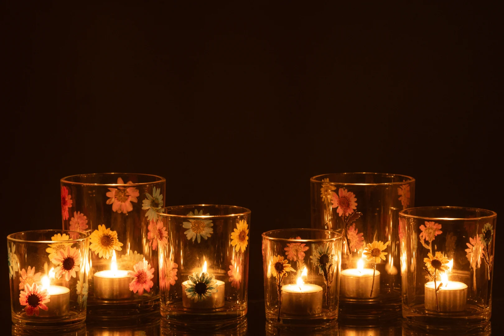 De Kaarsenhouder Orkaan Posy Glas Mix Groot Set van 2 heeft grote glazen kandelaars met levendige bloemmotieven, die elk warm opgloeien met een waxinelichtje en een gezellige sfeer toevoegen aan elke kamer.