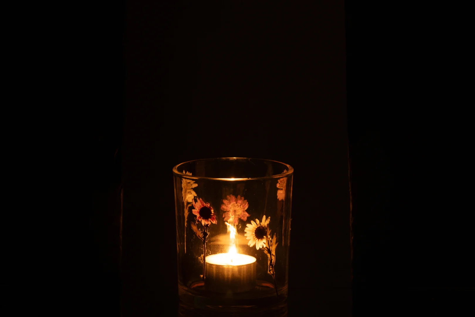 De Peggy Bloemen Glas Klein - Theelichthouder Kaarsenhouder gloeit warm in het donker en vult de kamer met licht als de kleine glazen houder, versierd met kleurrijke bloemmotieven, een brandende kaars prachtig weergeeft.