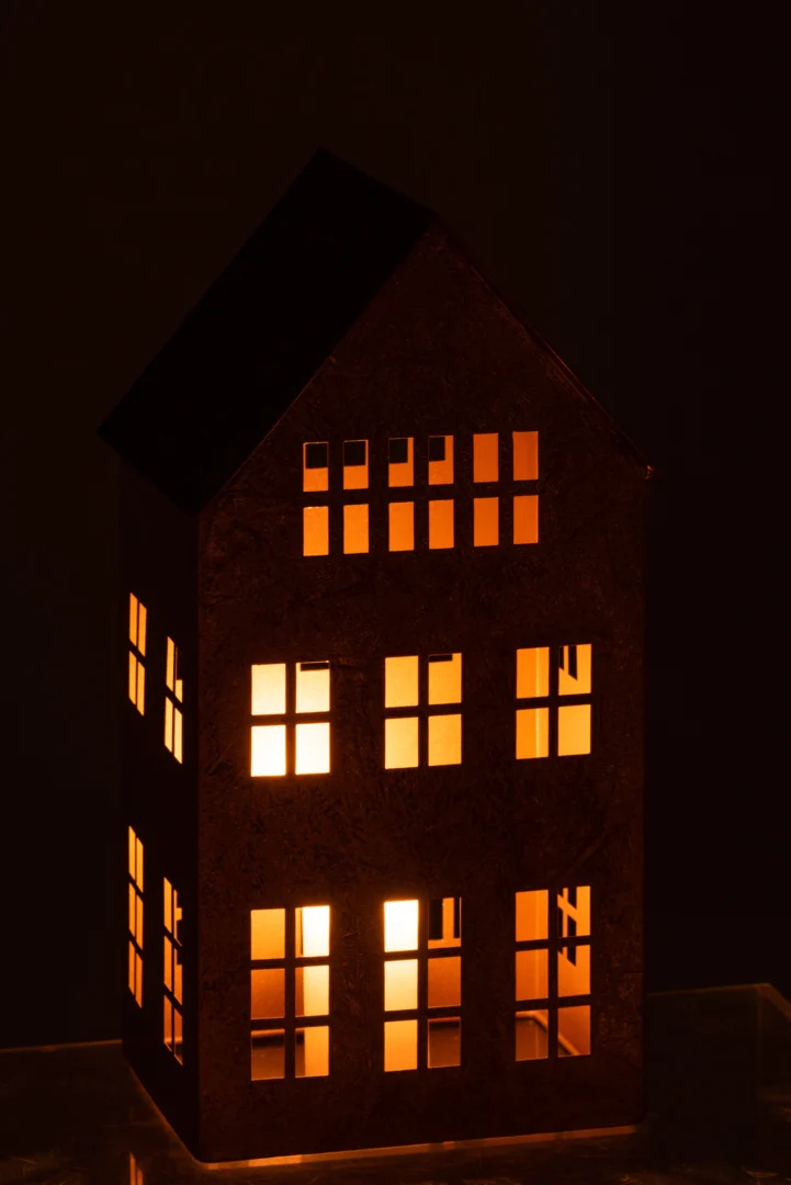 Het Kaarsenhouder Huis Sigma IJzer Goud is een decoratieve lantaarn in de vorm van een gouden huis. Het gloeiende licht schijnt door de vierkante ramen en creëert een charmant effect in het donker.