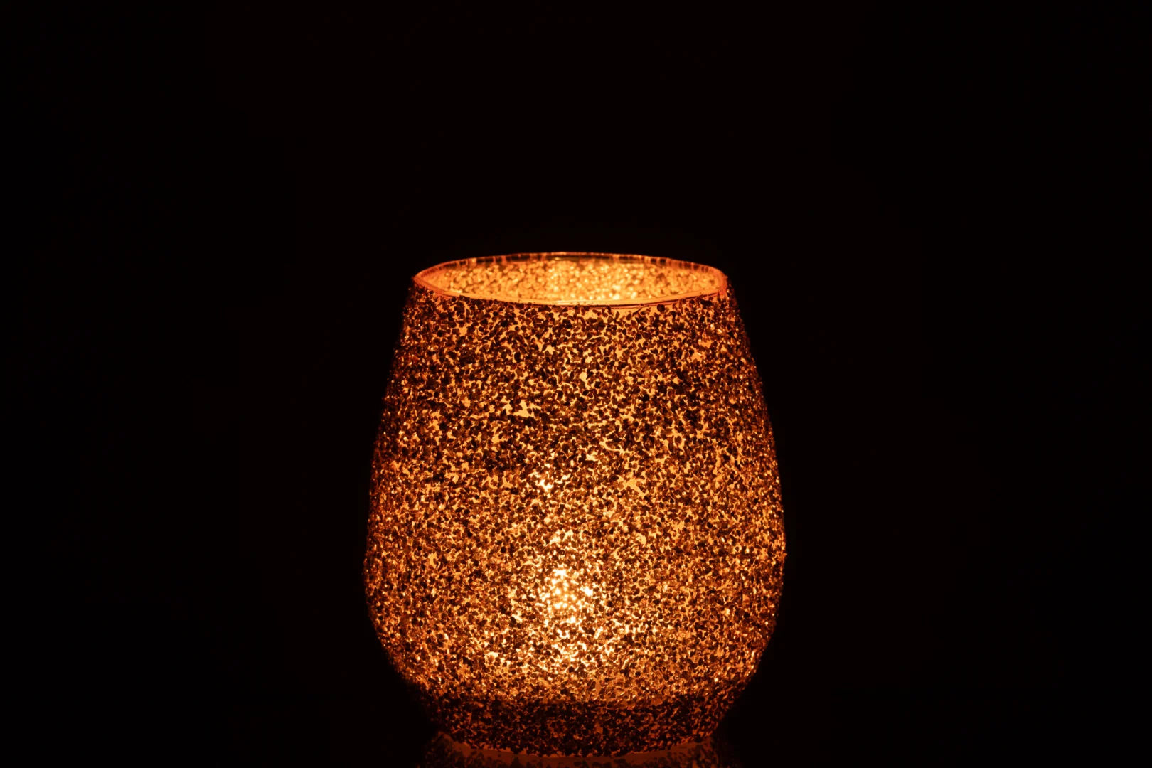 De Theelichthouder Glas Perzik Groot werpt een warme, gouden gloed door het getextureerde glas en voegt een gezellige en uitnodigende sfeer toe aan elke verduisterde ruimte.