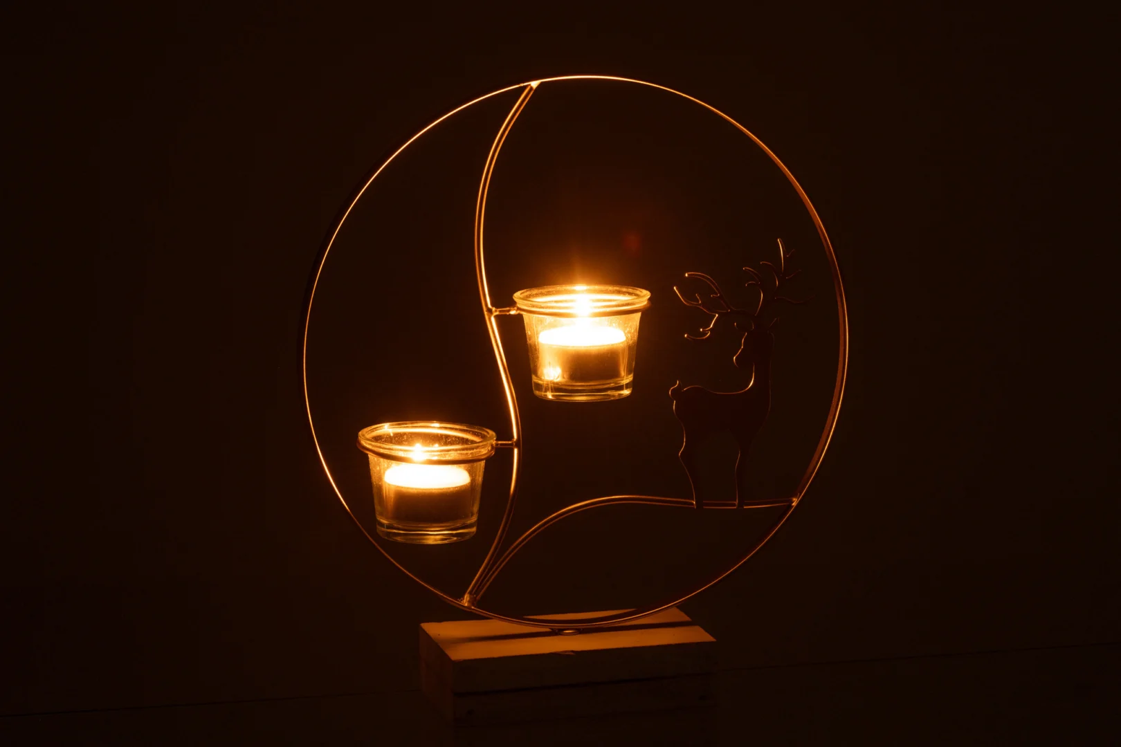 De Theelichthouder Rendier Rond Hout Goud Wit is een ronde houten en gouden kandelaar met glazen kopjes, voorzien van een rendiersilhouet dat elke ruimte prachtig verlicht.