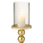 De Kaarsenhouder Aluminium Goudkleurig Klein heeft drie gouden bollen, een gestructureerde ronde basis en bovenkant, en een brandende witte pilaarkaars in een heldere glazen cilinder.