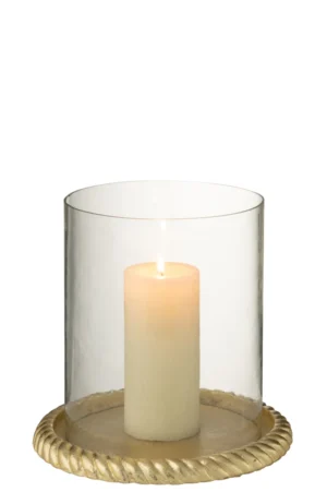 Een brandende witte pilaarkaars zit in de Kaarsenhouder Aluminium Goudkleurig, een helder glazen orkaanhouder met een ronde, goudkleurige aluminium basis met een gedraaid touwontwerp langs de rand.