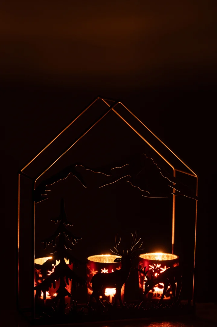 Theelichthouder Huis IJzer Roestbruin/Bruin 3 Glazen is een kandelaar in de vorm van een huis met boom- en hertensilhouetten, waarin drie waxinelichtjes passen die een warme gloed in het donker werpen.