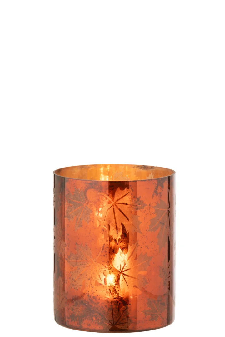 Een brandende kaars gloeit in de Kaarsenhouder Glas Roestbruin Groot, een oranje glazen houder met een metaalglans en geëtste bladmotieven, die een warme en gezellige sfeer uitstraalt tegen een witte achtergrond.
