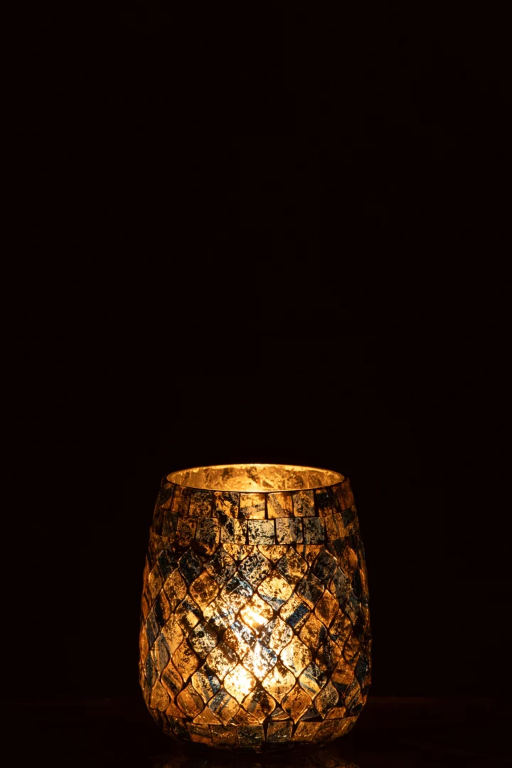Het Kaarsenhouder Mozaïekglas Grijs/Blauw gloeit warm in het donker met een brandende kaars erin en werpt ingewikkelde ruitvormige patronen op het oppervlak.