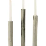 Drie witte conische kaarsen in de Kaarsenhouder Marmer Zwart Lichtgrijs Set 3 - hoge, cilindervormige marmeren kandelaars in zwart en lichtgrijs, elk met een ronde voet - worden getoond tegen een witte achtergrond.