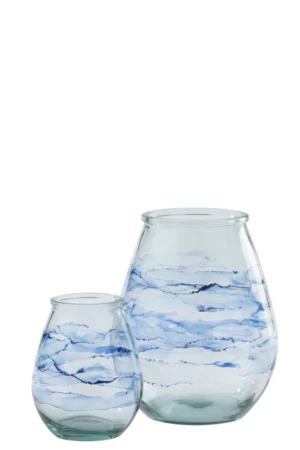 Twee Orkaan Golven Glas Blauw kaarsenhouders, gemaakt van helder glas met wervelende blauwe en witte motieven die doen denken aan aquarelstreken, worden weergegeven op een effen witte achtergrond. De ene houder is groter dan de andere.