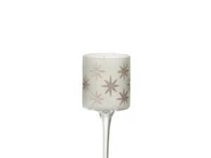 De Theelichthouder Op Voet Ster Glas Wit Goud Klein is een kleine kandelaar met een hoge steel en een matte cilindrische glazen kap met metallic gouden sterpatronen.