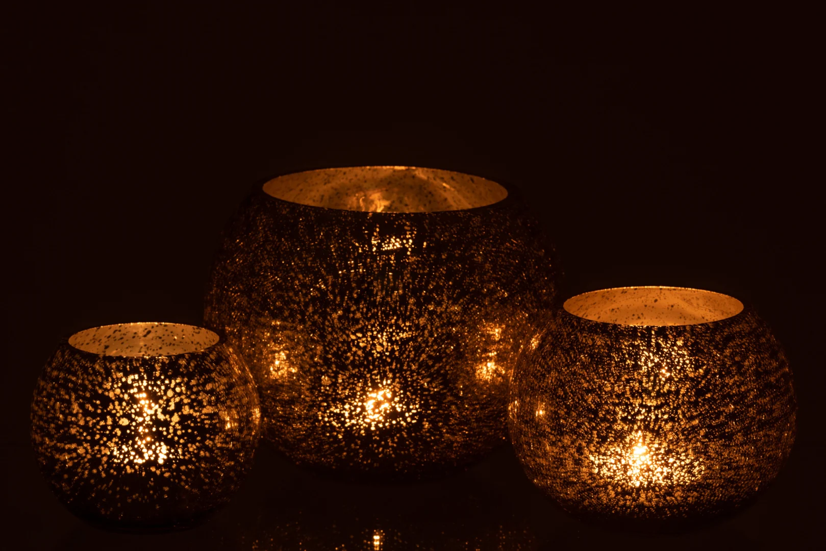 De Kaarsenhouder Orkaan Lichtbal Craquelure Glas Grijs Groot heeft een gestructureerd, metalen ontwerp dat warm oplicht in het donker, waardoor ingewikkelde patronen ontstaan en een gezellige sfeer wordt gecreëerd.