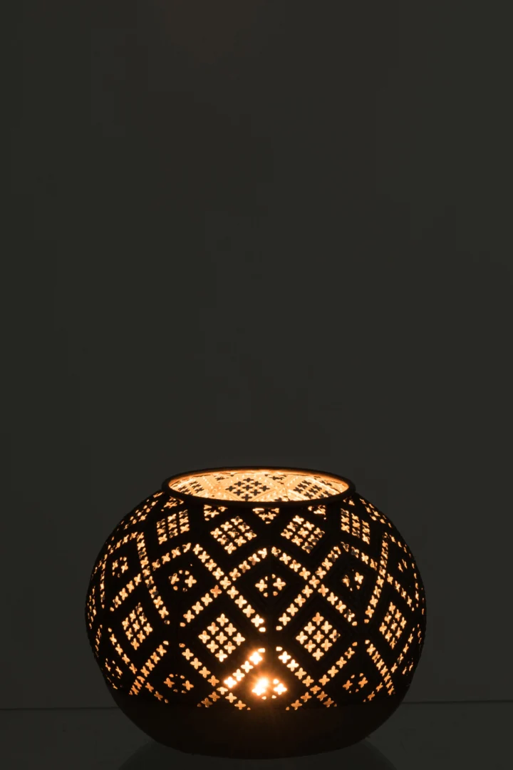 De Theelichthouder Bal Oosters Glas Bruin Antiek is een ronde lantaarn met ingewikkelde uitsparingen die warm, zacht licht en geometrische schaduwen werpt op het oppervlak en in de buurt.