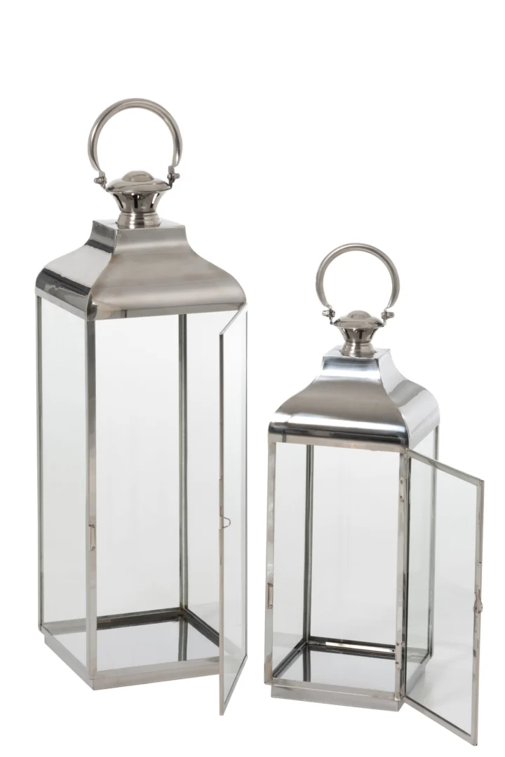 De Lantaarn Evi Ring Metaal Glas Zilver Set 2 bestaat uit twee rechthoekige lantaarns van glas en metaal met zilveren bovenkanten en ronde handgrepen - één open, één gesloten - beide leeg en uitgestald tegen een witte achtergrond.