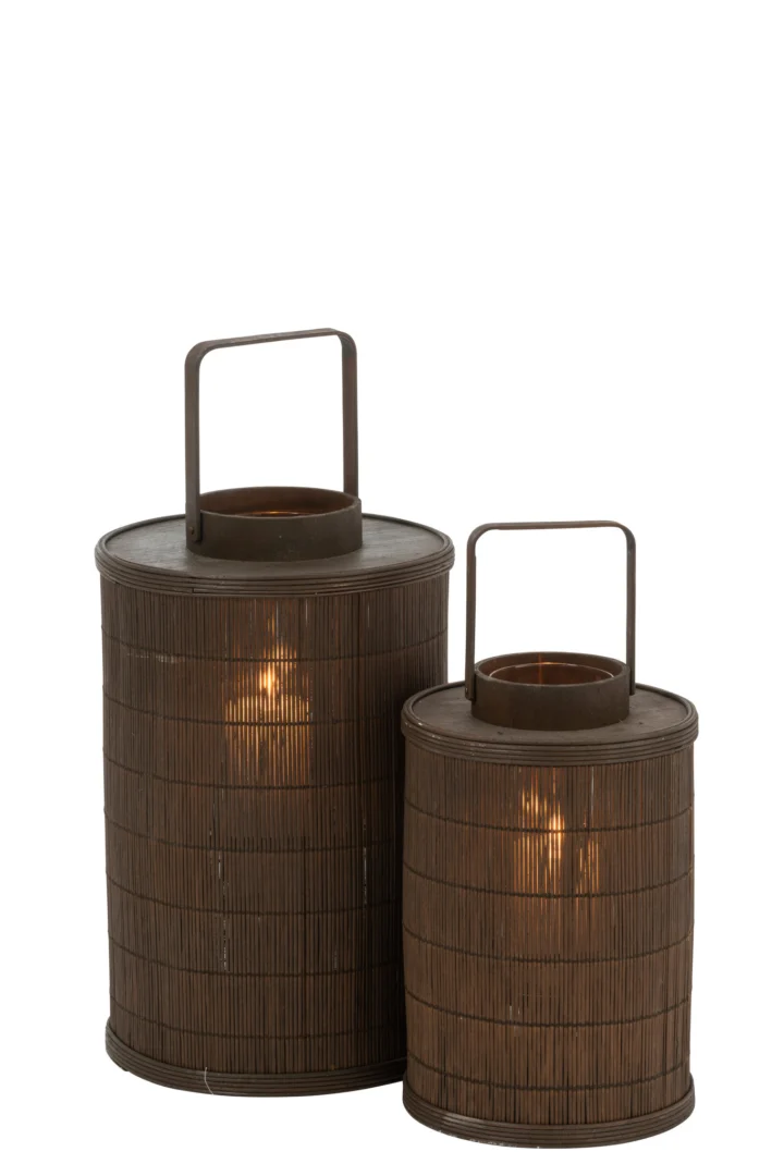 Twee cilindrische lantaarns van bruin bamboe, Kaarsenhouder Lantaarn Cilinder Bamboe Bruin Groot, een hoge en een korte, elk met verticale latten, metalen handvatten en een brandende kaars erin, tegen een witte achtergrond.