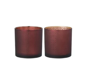 Een set van twee Kaarsenhouder Orkaan Oosters Glas Rood Goud kandelaars, met bordeauxrood glas met een geometrisch patroon en gouden binnenkant, naast elkaar op een witte achtergrond.