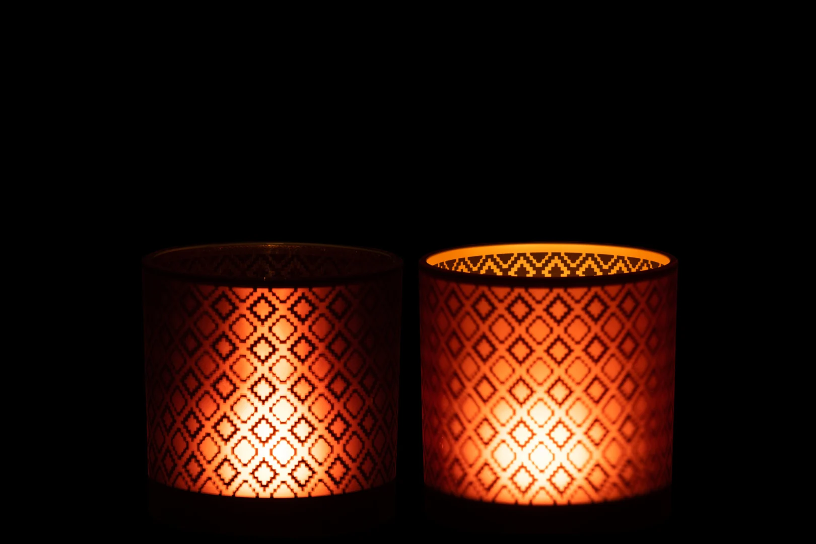 De Kaarsenhouder Orkaan Oosters Glas Rood Goud Set 2 bevat twee kandelaars met opvallende diamantpatronen die een warme gloed en ingewikkelde schaduwen uitstralen, perfect om een gezellige en uitnodigende sfeer toe te voegen aan elke ruimte.