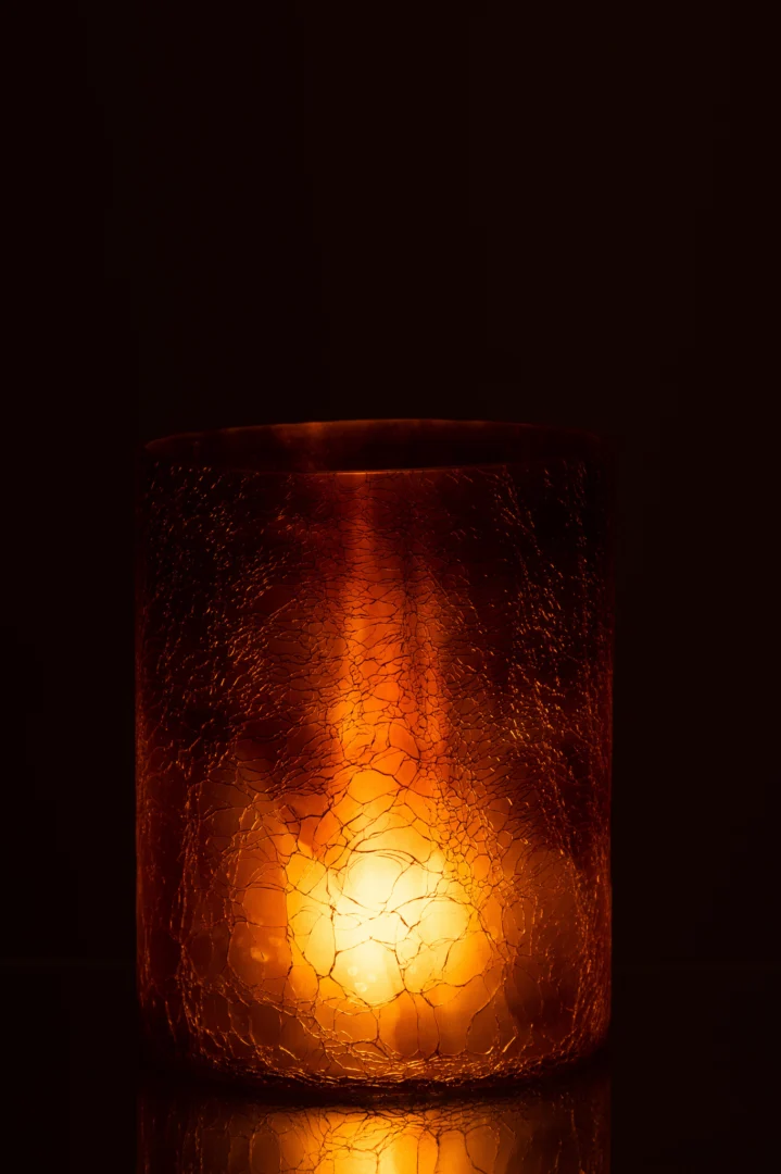 De Kaarsenhouder Orkaan Glas Oker Groot heeft een gebarsten, oranje glazen oppervlak met structuur dat een warme, zachte gloed uitstraalt en een gezellige en sfeervolle sfeer creëert in elke donkere omgeving.