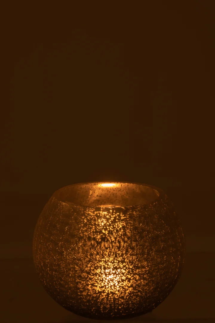 De Kaarsenhouder Orkaan Bal Kraakglas Zilver Middelgroot straalt een warme, gouden gloed uit bij gedimd licht. De gebarsten glasstructuur creëert een gezellige en uitnodigende sfeer.