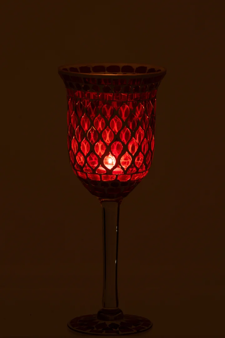 De Kaarsenhouder Op Voet Mozaïek Glas Rood Wit Klein is een kleine rood met wit mozaïek glazen kaarsenhouder op een standaard, die een zachte, warme gloed afgeeft wanneer er een kaars in brandt, perfect om een gezellige sfeer te creëren in een donkere omgeving.