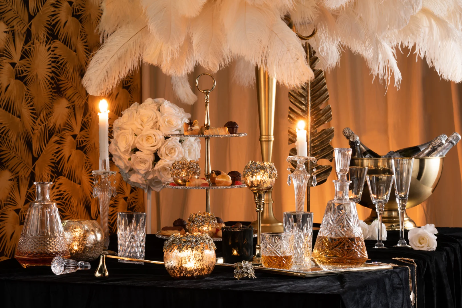 Een rijkelijk gedekte tafel met kristallen karaffen, glazen, witte rozen, een gouden dienblad met lekkernijen en de Kaarsenhouder Parelglas Transparant Klein. Een ijsemmer koelt de champagne. De vintage inrichting voelt glamoureus en elegant aan.