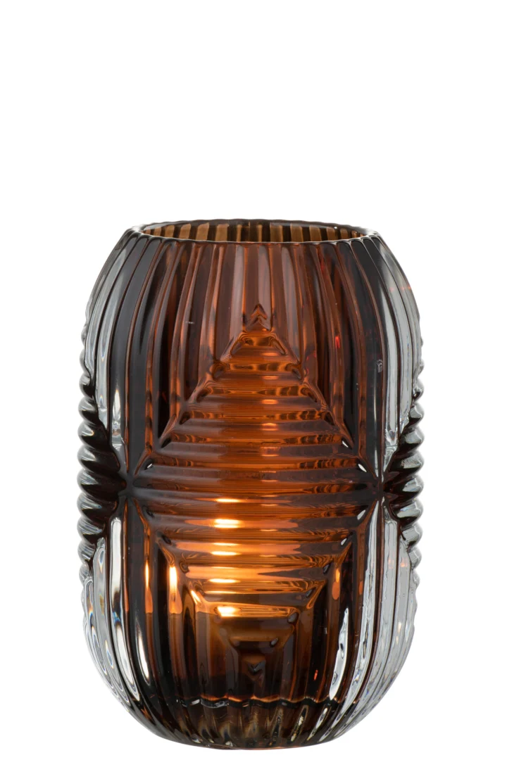 De Theelichthouder Hoge Lijnen Glas Bruin is een bruine glazen kandelaar met een geribbeld, geometrisch patroon dat warm oplicht wanneer er een kleine kaars in brandt.