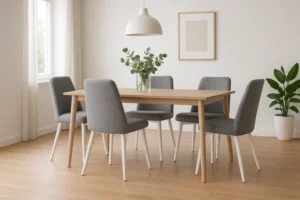 Een moderne eetkamer met een houten tafel, vier grijze stoelen met witte poten - perfect voor diegenen die zich afvragen "Hoe stijl je grijze eetkamerstoelen" -, een plant in pot, een witte hanglamp, een leeg fotolijstje en een groene plant in de hoek.