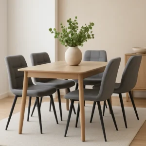 Hoe vind je stijlvolle en toch goedkope meubels? Deze lichthouten eettafel met vier grijze stoelen met kussens op een beige vloerkleed biedt een elegante look. Een ronde witte vaas met groene bladertakken maakt de minimale, neutraal getinte kamer helemaal af.
