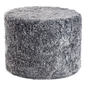 De Poef Schapenvacht Krullend Korte Wol M14 is een ronde, grijze voetenbank met zachte, gekrulde stof van imitatiebont voor een pluche textuur en een knusse uitstraling.